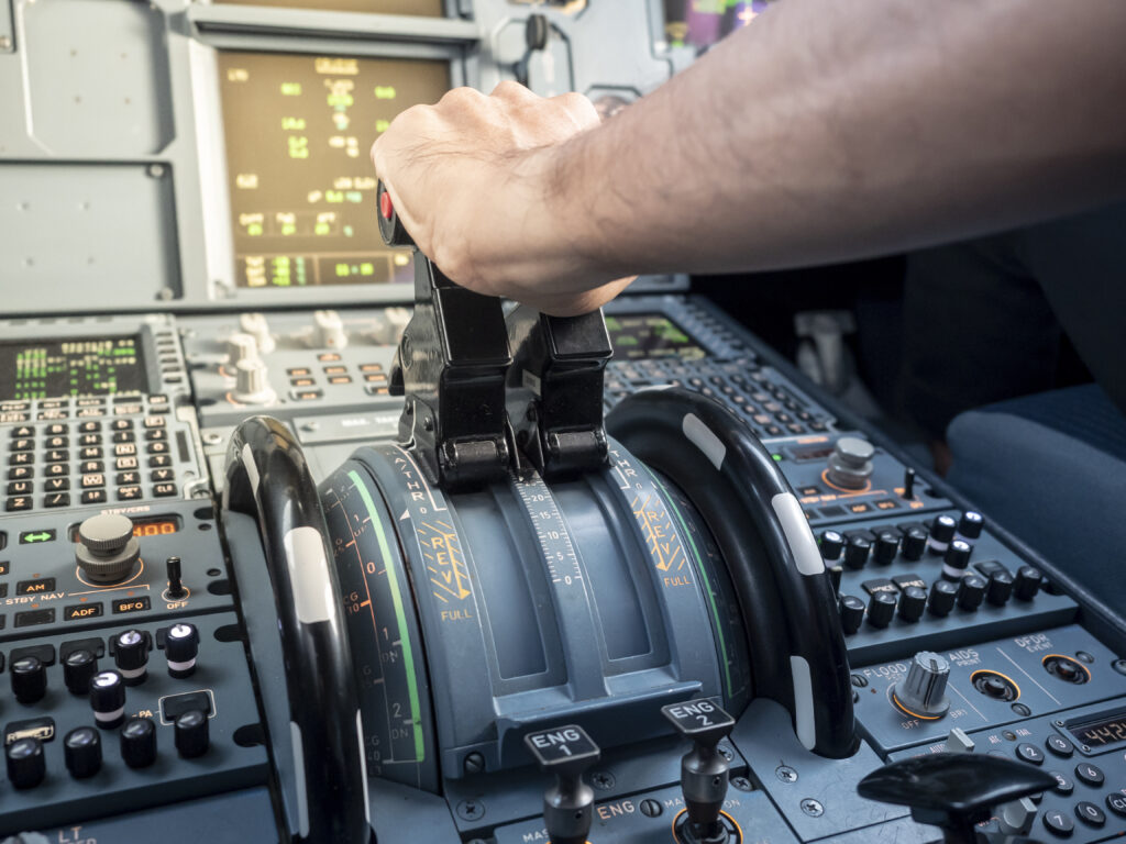 pilot hand on thrust lever in A320 aircraft. warm sunlight in co